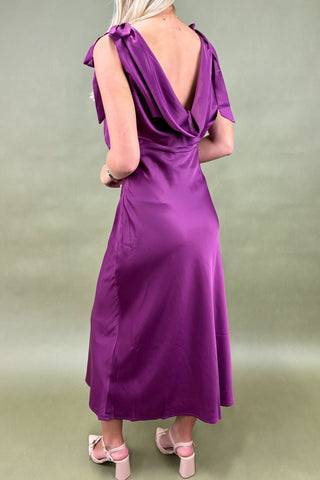 Purple dress with a deep neckline and ruffled sleeves on a plain background