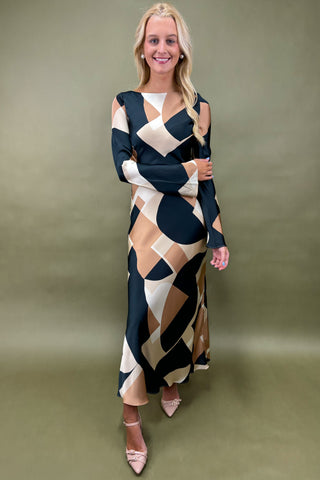Woman wearing a patterned dress against a plain background