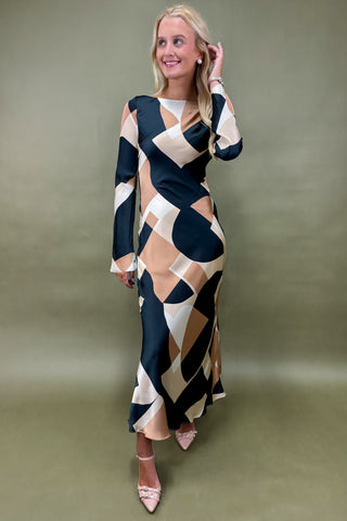 Woman wearing a patterned dress against a plain background