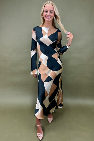Woman wearing a patterned dress against a plain background