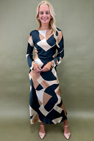 Woman wearing a patterned dress against a plain background