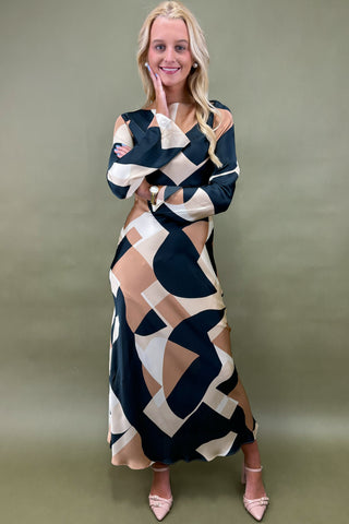 Woman wearing a patterned dress against a plain background