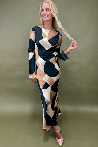 Woman wearing a geometric patterned dress against a plain background