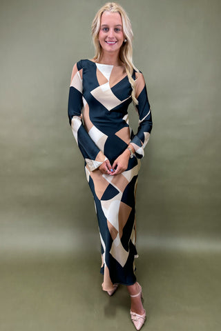 Woman wearing a patterned dress against a plain background