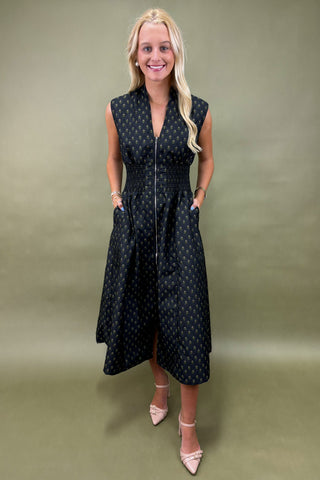 Woman wearing a black polka dot dress against a green background