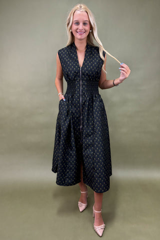 Woman wearing a black polka dot dress against a beige background