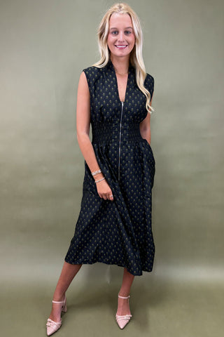 Woman wearing a black polka dot dress against a green background