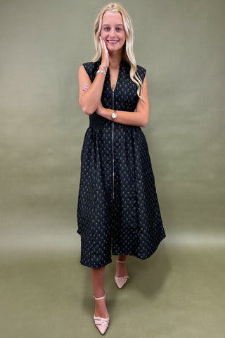Woman wearing a black polka dot dress against a green background
