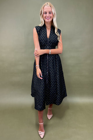 Woman wearing a black polka dot dress against a green background