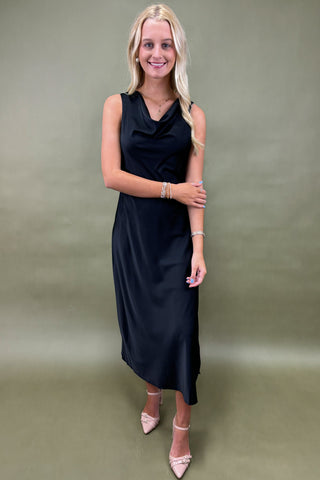 Woman wearing a black dress against a plain background