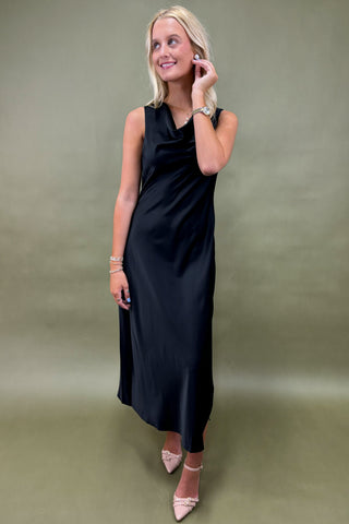 Woman wearing a black dress against a plain background