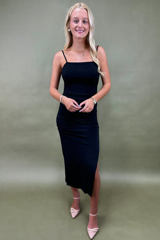 Woman wearing a black dress against a plain background
