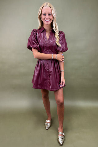 Woman wearing a purple dress against a plain background