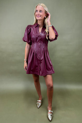 Woman wearing a purple dress against a green background