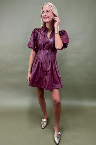 Woman wearing a purple dress against a green background