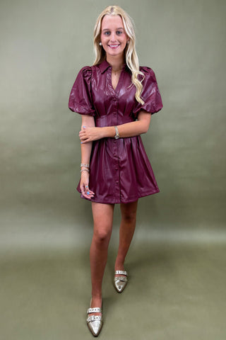 Woman wearing a purple dress against a plain background