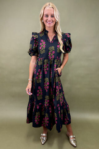 Woman wearing a floral dress against a plain background