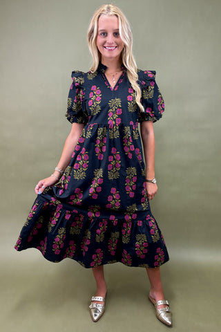 Woman wearing a dark floral dress against a green background