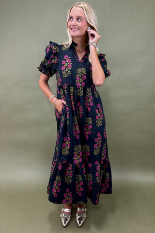Woman wearing a dark floral dress against a green background