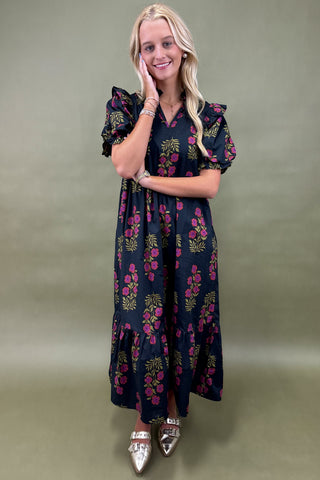 Woman wearing a dark floral dress against a green background