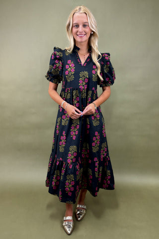 Woman wearing a floral dress against a plain background