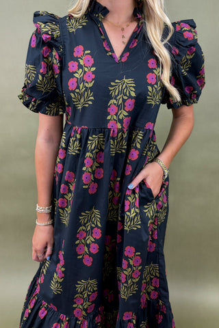 Woman wearing a floral dress with puff sleeves against a neutral background
