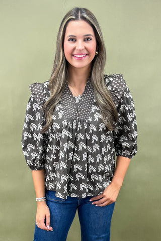 Brown floral smocked blouse with ruffle shoulders and balloon sleeves paired with wide-leg denim jeans for a chic fall outfit