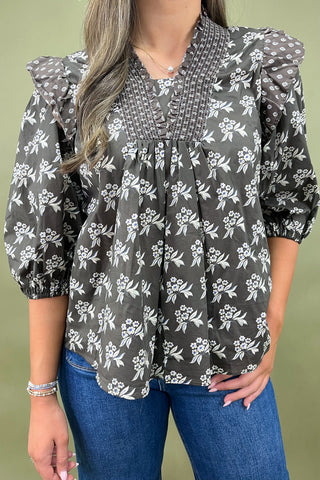 Brown floral smocked blouse with ruffle shoulders and balloon sleeves paired with wide-leg denim jeans for a chic fall outfit