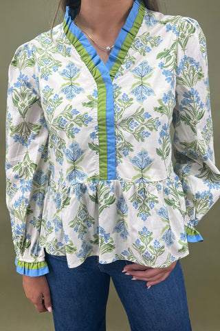 Floral patterned blouse with green and blue accents on a plain background