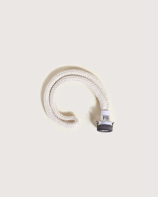 White coiled hose with a nozzle on a beige background