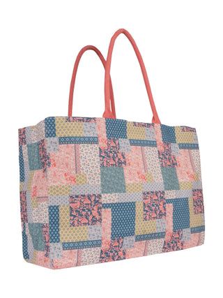 Patchwork patterned tote bag with pink handles on a white background