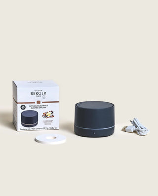 Black diffuser with packaging and power cord on a beige background