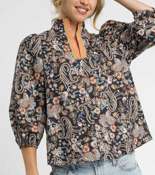 Woman wearing a floral blouse with a neutral background