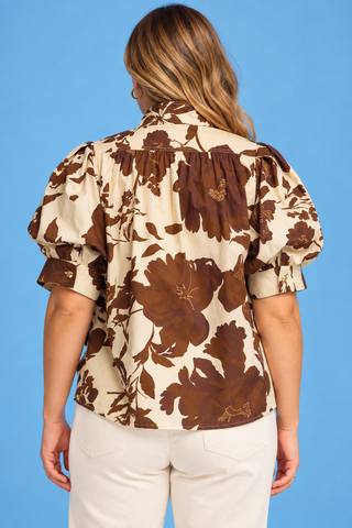 a cream-colored blouse with a brown floral pattern and puff sleeves