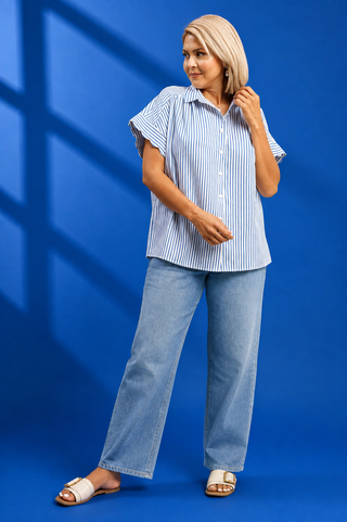 A woman modeling a short-sleeve button-up shirt with vertical blue and white stripes