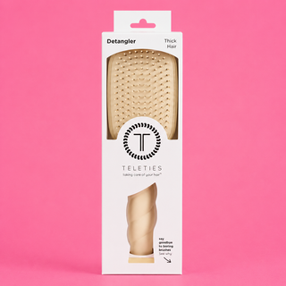 Packaging of a hair detangler brush with 'Teleties' branding on a pink background