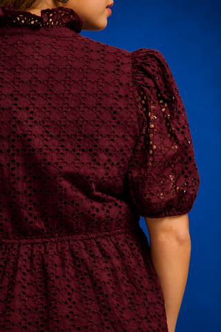  a burgundy eyelet lace short-sleeve blouse with puff sleeves and a scalloped hem