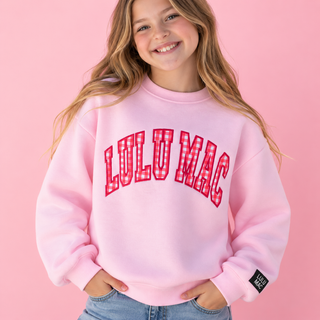 a pink crewneck sweatshirt with 'LULU MAC' printed in red and white gingham lettering