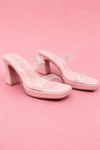 Pink high-heeled shoes with clear straps on a pink background
