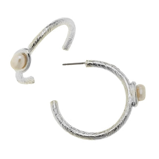 Silver hoop earrings with pearl accents on a white background