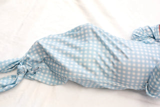 Blue and white checkered fabric with a knot on a light background