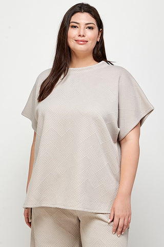 Woman wearing a beige oversized top and pants on a white background