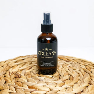 Bottle of Orleans home fragrances on a woven surface