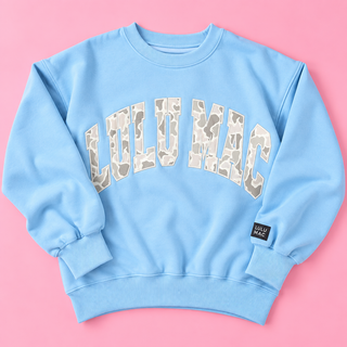 blue sweatshirt features bold collegiate-inspired LULU MAC lettering filled with a subtle light camouflage pattern