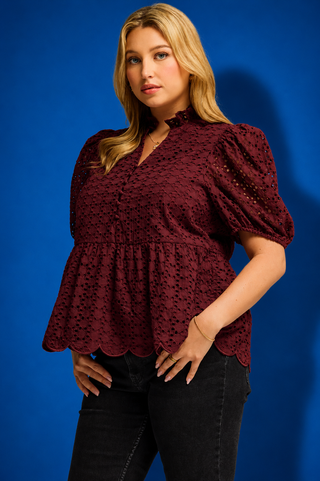  a burgundy eyelet lace short-sleeve blouse with puff sleeves and a scalloped hem