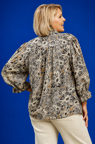 Woman wearing a floral blouse against a blue background