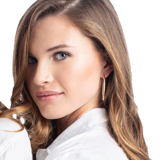 Close-up of a woman with long blonde hair wearing a white shirt on a white background