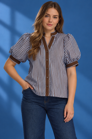 A woman modeling a short-sleeve button-up shirt with vertical blue and white stripes, brown trim