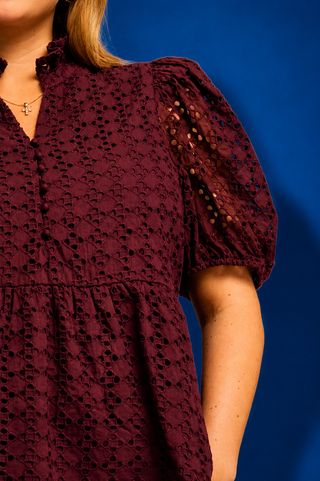  a burgundy eyelet lace short-sleeve blouse with puff sleeves and a scalloped hem
