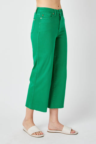 Green pants worn by a person on a white background